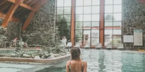 Mujer en piscina techada de Hotel Termas de Puyehue con piedra, madera y agua